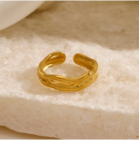 Macro detail of gold plated irregular wavy ring on natural white crystal stones