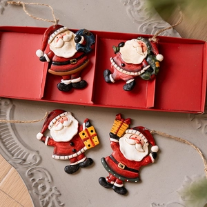 Set of 4 vintage resin Santa Claus ornaments with hanging ropes on a red festive tray