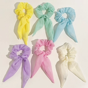 Flat lay of six colorful chiffon LED hair scrunchies with long ribbons on white background