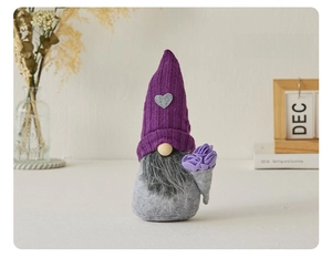 Close-up of lavender knitted gnome doll with grey heart patch and felt flowers