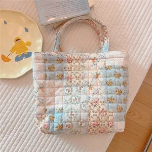 Quilted floral tote bag with pastel patchwork and 'simple wish' tag on soft bedding