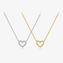 Macro view of minimalist hollow heart necklaces in polished gold and silver plated copper