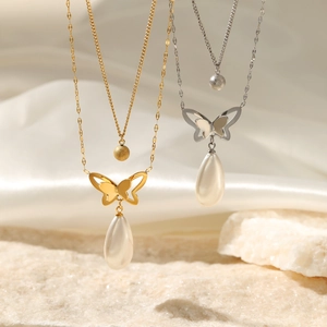 Double layered 14K gold and silver butterfly pearl pendant necklace on silk backdrop