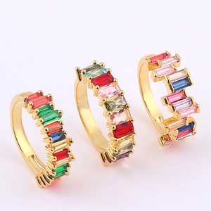 Macro shot of gold-plated rainbow eternity rings with multi-color rectangular crystals