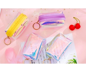 Detailed view of colorful holographic mini coin purses with rose gold keychains on pink mesh