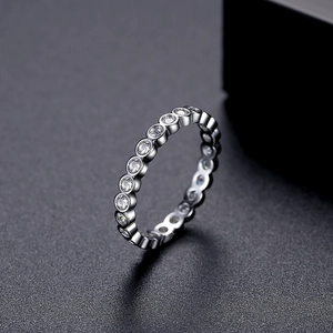 Minimalist silver bezel-set cubic zirconia ring on a professional matte grey backdrop