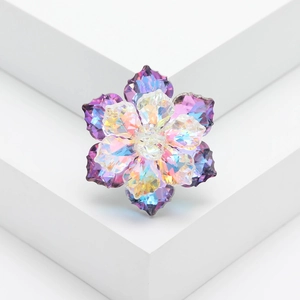 Detail of colorful faceted crystal flower brooch with AB coating on white background