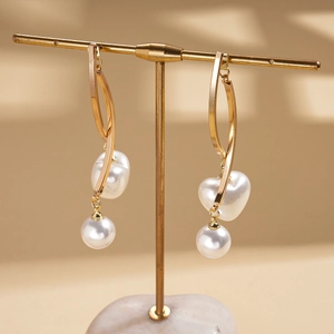Détail de boucles d'oreilles cœur doré et perles sur support avec un éclairage élégant