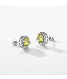 Macro detail of silver stud earring featuring yellow gemstone and halo diamond setting