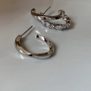 Detailed view of silver asymmetric star earrings with sparkling cubic zirconia stones