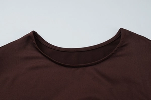 Détail de l'encolure ronde et des coutures sur cette robe marron café à manches longues