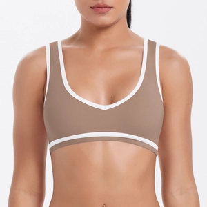 Détail frontal du soutien-gorge de sport respirant kaki avec bordure blanche contrastée