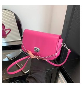 Détail du petit sac carré fuchsia avec boucle argentée et bandoulière en chaîne