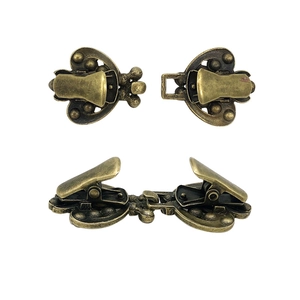 Vintage bronze rhinestone sweater clips with decorative pattern shown on white background