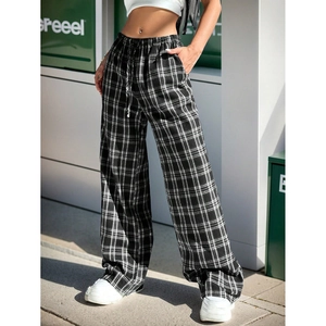 Detail of black and white plaid wide-leg trousers featuring a drawstring elastic waistband