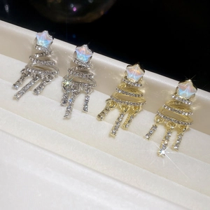 Macro shot of silver needle Christmas tree tassel earrings with sparkling rhinestones