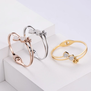 Three minimalist double heart bangles in gold, silver, and rose gold with rhinestones