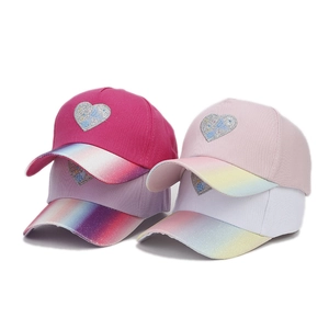 Detail of four girls baseball caps in rose, purple, pink and white with glitter brims