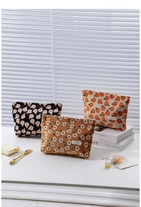 Detailed set of three floral corduroy cosmetic bags in black brown and cream with zippers