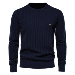 Close-up of navy blue men sweater showing intricate diagonal knit texture and metal tag