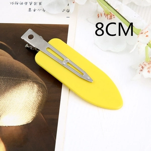 Detail of yellow seamless hair clip with 8cm metal duckbill design on a book