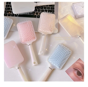 Detailansicht der perlmuttfarbenen Paddelbürsten in Rosa, Blau und Creme-Pastelltönen