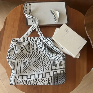 Detailed overhead view of a bohemian geometric canvas tote bag on a wooden table setup