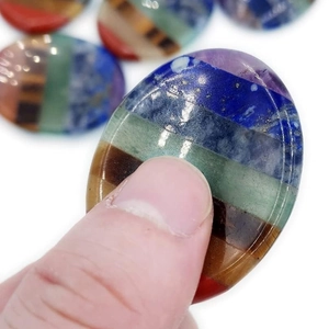 Handheld oval rainbow chakra worry stone with polished multi-layer healing crystals