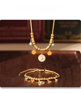Detail of PVD plated turquoise sun pendant necklace and matching gold beaded bracelet