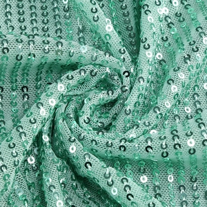 Macro view of mint green sequins stitched on breathable mesh fabric for dresses