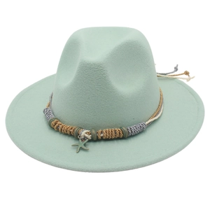 Dettaglio del cappello fedora verde menta con ciondolo a stella e fascia in corda intrecciata