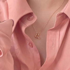 Detailed view of a minimalist 925 silver heart pendant necklace in rose gold on a model