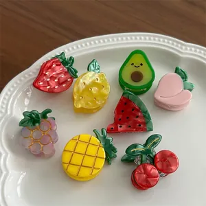 Cute fruit hair clips set including strawberry and lemon shapes on a ceramic plate