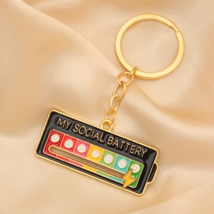 Detail of social battery keychain showing a colorful enamel gradient and gold metal finish