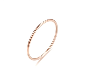 Macro shot of polished rose gold thin band ring with a glossy finish on a white surface