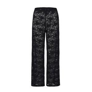 Close-up of semi-sheer black floral lace fabric on high-waist straight-leg trousers