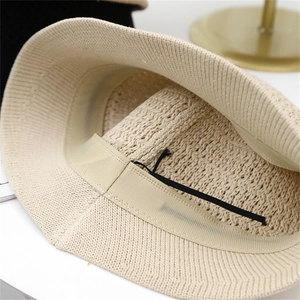 Close-up of the beige knitted bucket hat interior with sweatband and adjustable drawstring