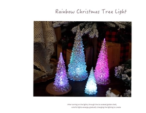 Macro shot of colorful acrylic mini Christmas trees with ice crystal texture on lace