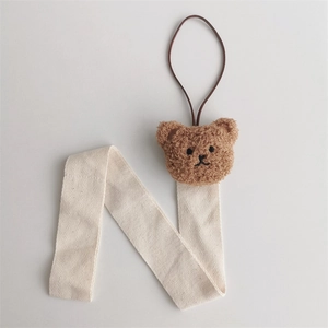 Detail of plush bear head with beige herringbone ribbon hair clip organizer strap