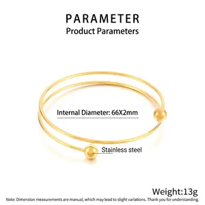 Detail of minimalist gold double-layer stainless steel bangle with spherical bead ends