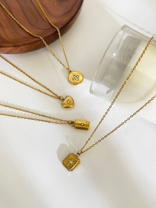 Macro shot of gold pendant necklaces featuring heart, square, and round crystal charms