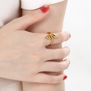 Détail d'une bague serpent vintage dorée avec œil en diamant portée sur un mannequin