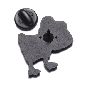 Macro shot of metal enamel pin back featuring black rubber clutch and needle fastener