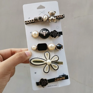Close-up of candy-colored hair clip set featuring pearls, resin bears, and gold alloy details