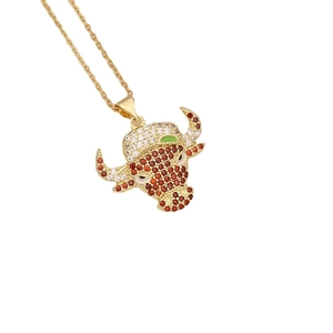 Gold bull head necklace with red and white cubic zirconia and green enamel details