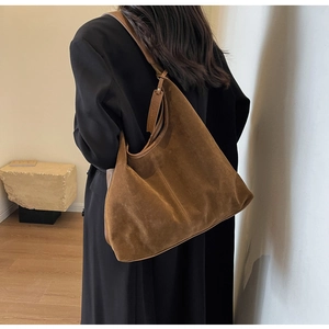 Brown suede hobo bag shown on a shoulder with minimalist style for daily commuting