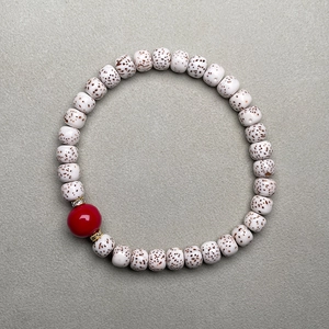 Macro detail of Star Moon Bodhi seed bracelet featuring a red agate bead and gold spacers