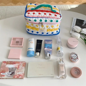 Vue détaillée de dessus d'une trousse à maquillage matelassée à pois avec grande capacité