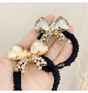 Close-up of crystal bow hair ties in champagne and grey with rhinestone alloy details