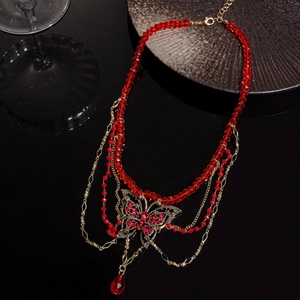 Vue détaillée du collier papillon rouge avec cristaux sur chaîne dorée multicouche